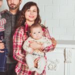 A joyful family posing together in a cozy living room, embodying love and togetherness.